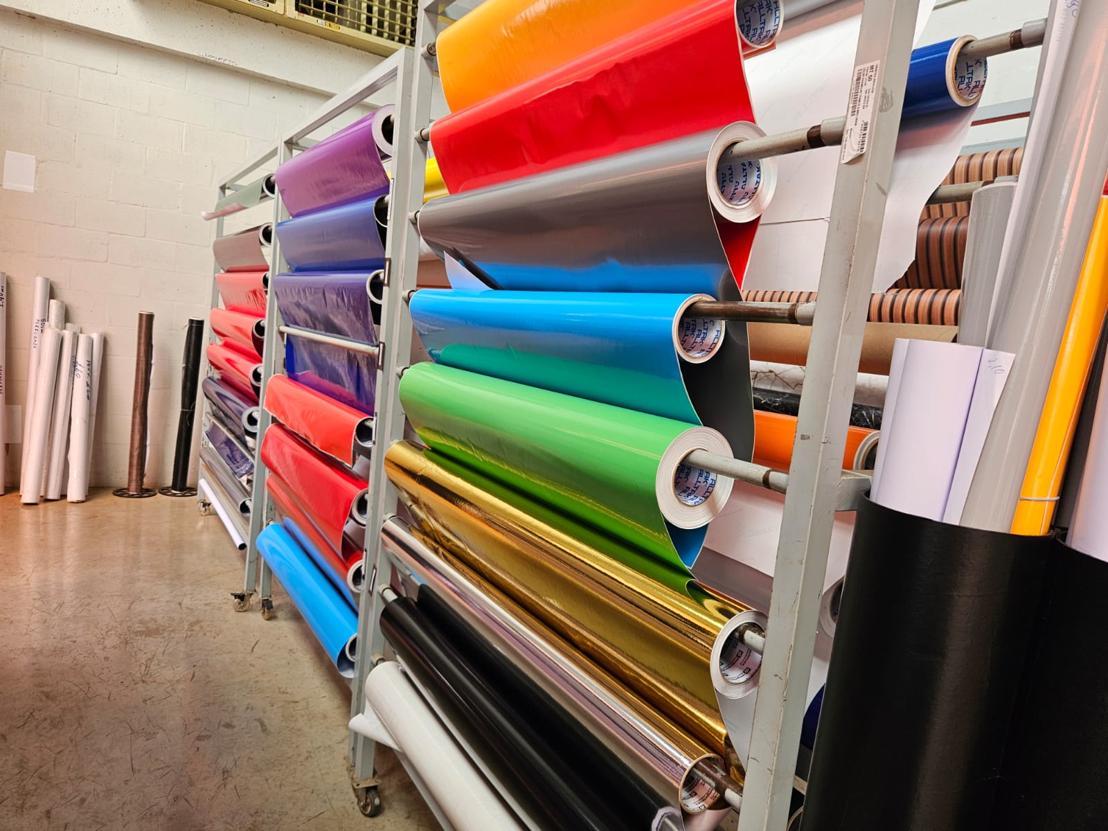 Rolos de vinil colorido organizados em estoque